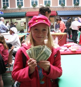 A young business owner shows off her cash profits at the end of the Young Entrepreneurs Marketplace.