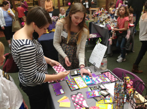 A customer browses fancy duct tape wallets at the Spring Young Entrepreneurs Marketplace.