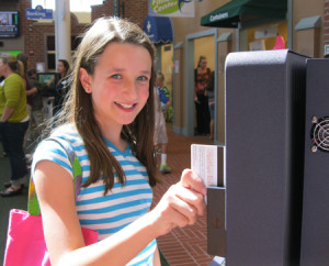 A student from Timber Trail Elementary School swipes her debit card to check her balance.