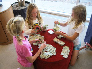 The girls count and sort donated bills before making their bank transaction.