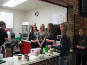 The students toured another local school to share insights and learn from others' business experiences.