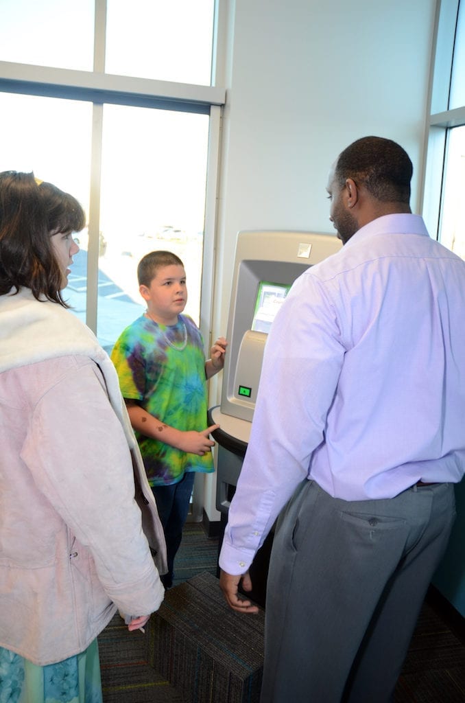 Young Americans Bank customer learns how to use an ATM