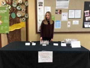 Delaney stands behind a booth with her lipcare products