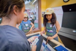 Students in the King Soopers Market make a sale with a credit card from a Towne participant