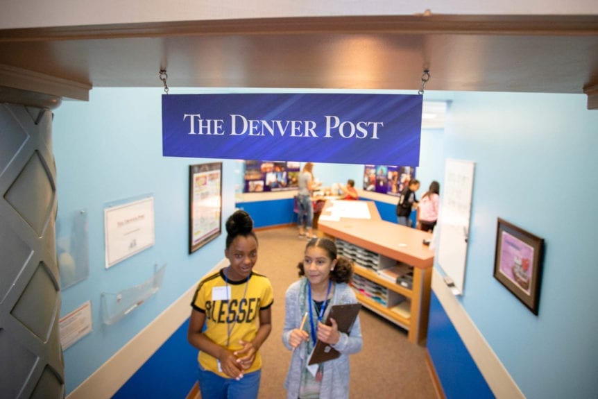 The Denver Post Sign with Students Walking Below. Young Americans Center for Financial Education first partnered with The Denver Postnearly 20 years ago to create a life-like Newspaper shop.  Volunteers from The Denver Posteven renovated the shop by painting and creating artwork to hang on the walls.  Today, in addition to financial support from Denver Post Educational Services via Colorado NIE , the Post continues to provide shop enhancements like aprons, lanyards, clipboards, and pencils for 5th-grade Newspaper employees.  Thanks to The Denver Post, students feel like they are working for a real newspaper.