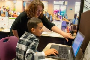 A Fidelity Investments employee assists a student on the computer