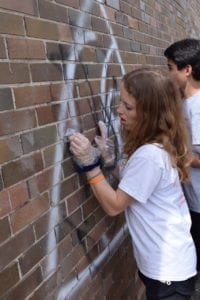 Two students, Gabriel Nagel and Elisa, remove graffiti from a Denver-Metro Alley. On Friday, April 5, the student leaders of McAuliffe International completed a whole day of service as the culminating activity of Spark Change, a new program of Young Americans Center for Financial Education teaching philanthropy through service learning.  This outstanding group of 6th-8th graders has worked together since the fall researching local nonprofits and leading their school in collecting change to donate to these nonprofits.  The 50 student leaders who participated in the day of service made a big impact on their community.