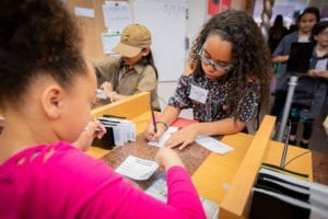 Young AmeriTowne Bank customers write checks at the bank