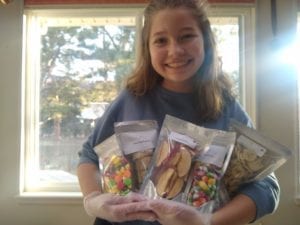 Reina Crowley, owner of Mile High Freeze Dry, showing sample packages of her freeze dried goodies.