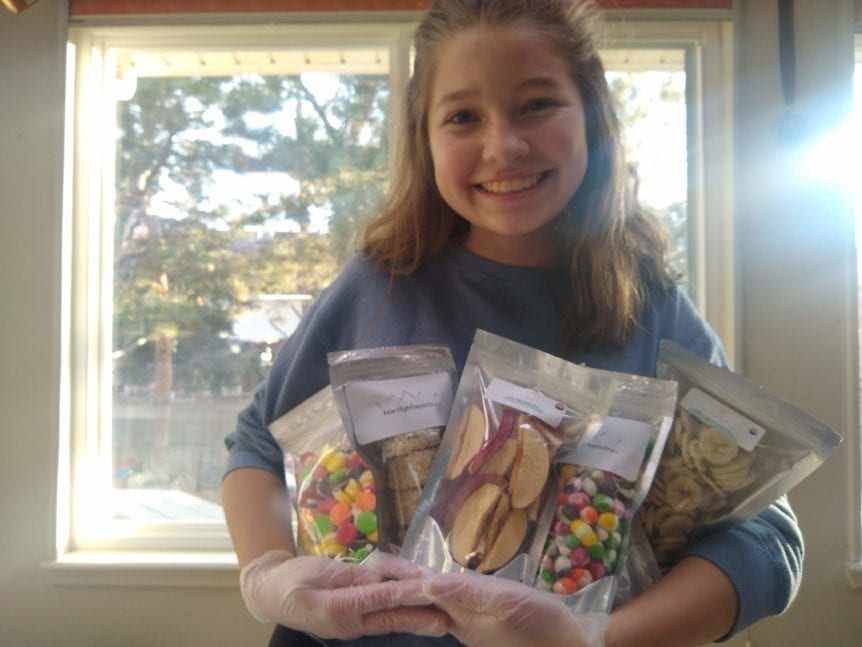 Reina Crowley, owner of Mile High Freeze Dry, showing sample packages of her freeze dried goodies.