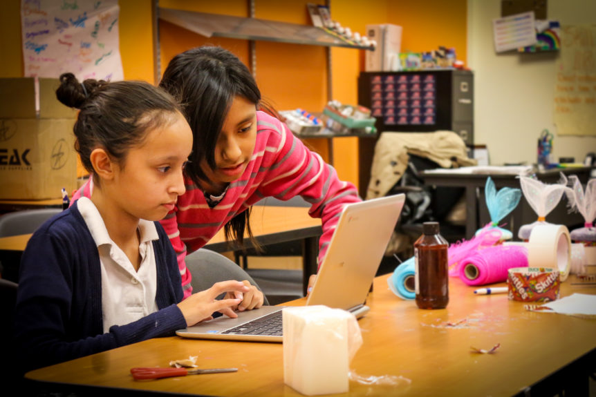 Two girls building a product prototype and looking at a laptop screen for Youthbiz