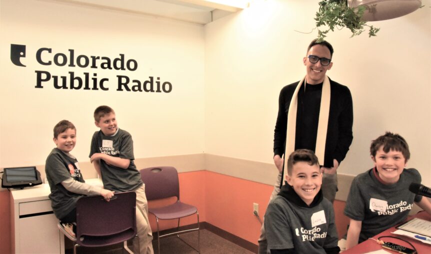Ryan Warner poses with four students in the Radio Station in Young AmeriTowne