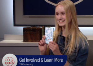 Anna Brekken shows one of her handmade cards to the camera on Colorado and Company