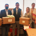JP Morgan volunteers hold boxes of supplies they filled for YouthBiz StartUp